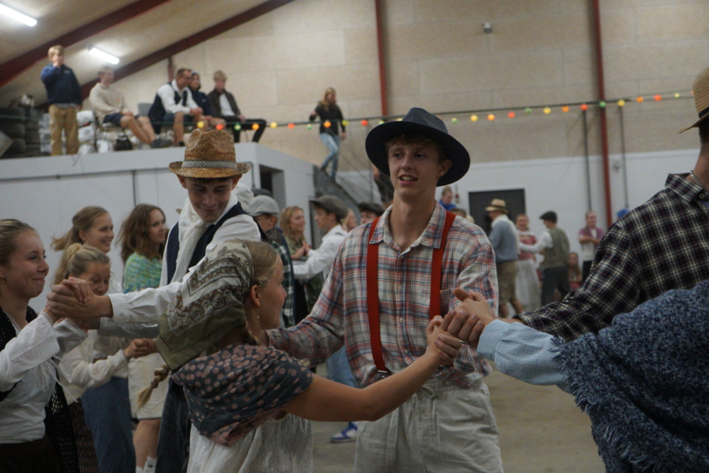 Billedet viser eleverne, der danser folkedans i laden på gården Rødkilde.