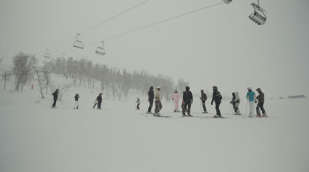 Billedet viser en gruppe efterskoleelever fra Gørlev Idrætsefterskole, der står på ski. I baggrunden ses flere stolelifte.