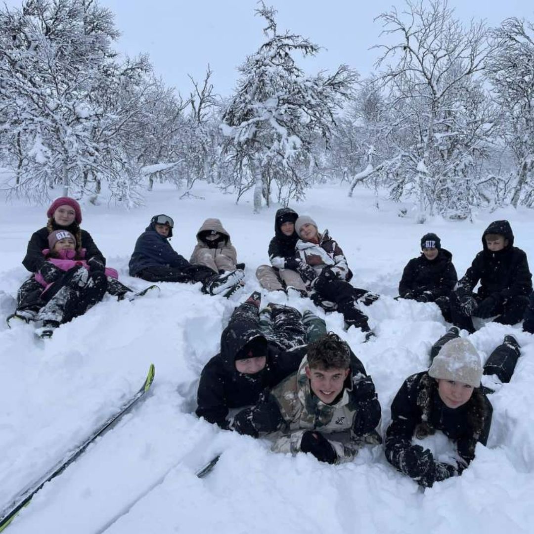 En gruppe efterskoleelever ses i sneen, hvor de hygger sig med hinanden. De er på lejrskoletur i Sverige.